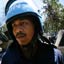Moustached man wearing blue helmet with UN printed on front