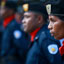 Side view of three officers in blue uniforms with red scarves
