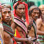 Five men dressed colourful clothes and headress