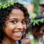 Young girl wearing green laurel smiles for the camera